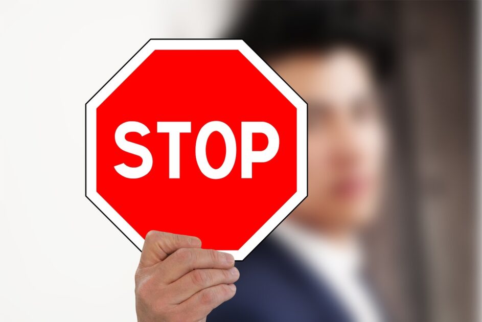 STOPの標識を向けている男性