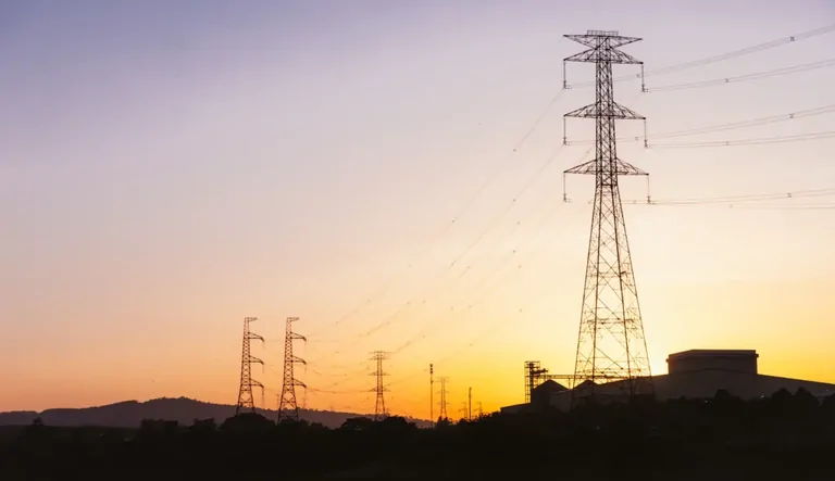 夕焼けの空に浮かぶ送電線と鉄塔。AI時代の電力インフラの安全を考える記事のアイキャッチ